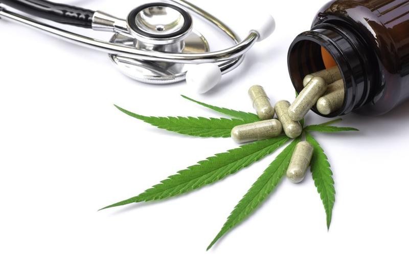 Photo à caractère médical avec un stéthoscope, une boite de gélules et une feuille de cannabis